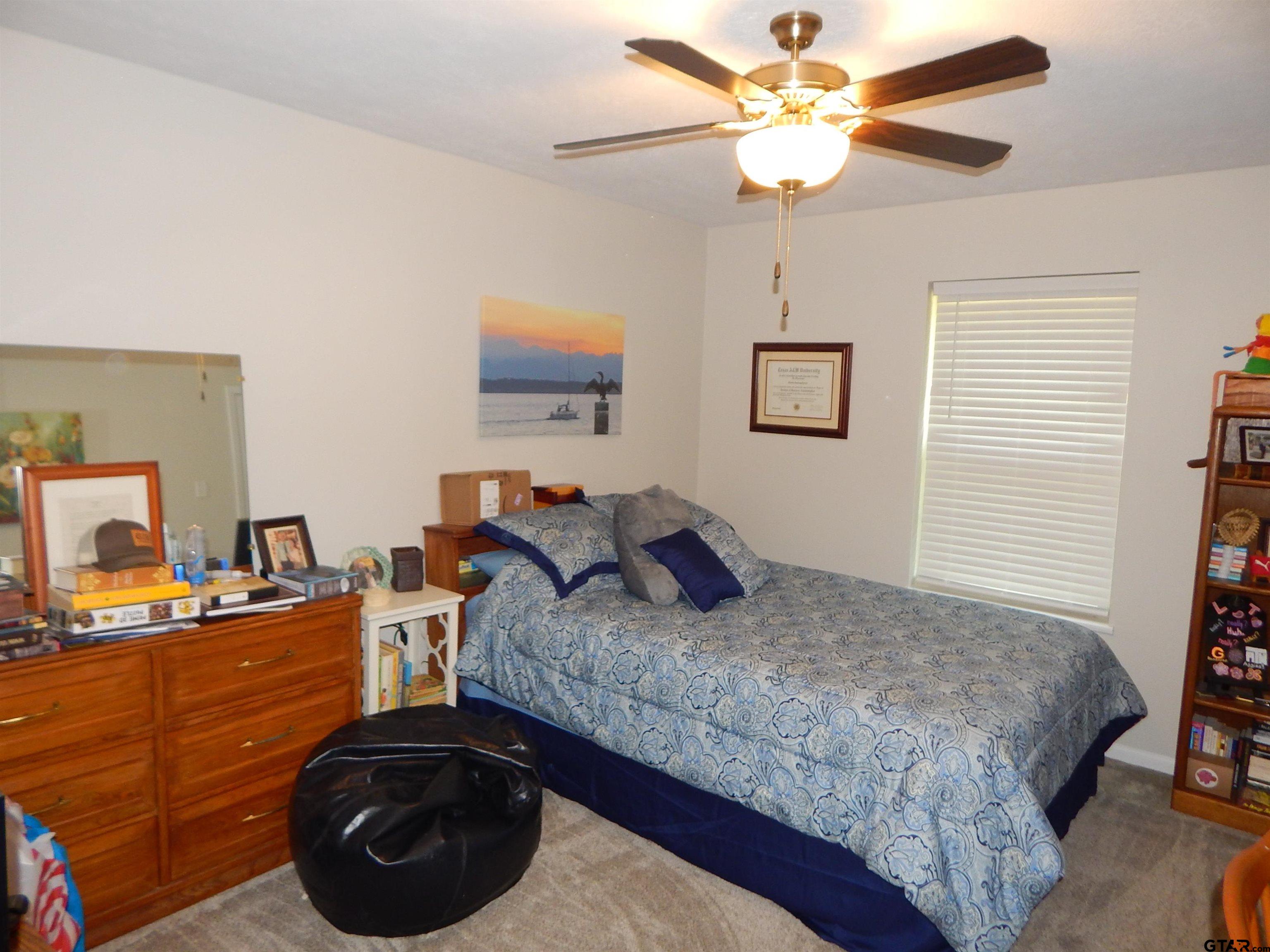 3035 Arrowwood Road Gilmer, TX 75644 - Photo 20 of 32 a bedroom with a bed and a chandelier