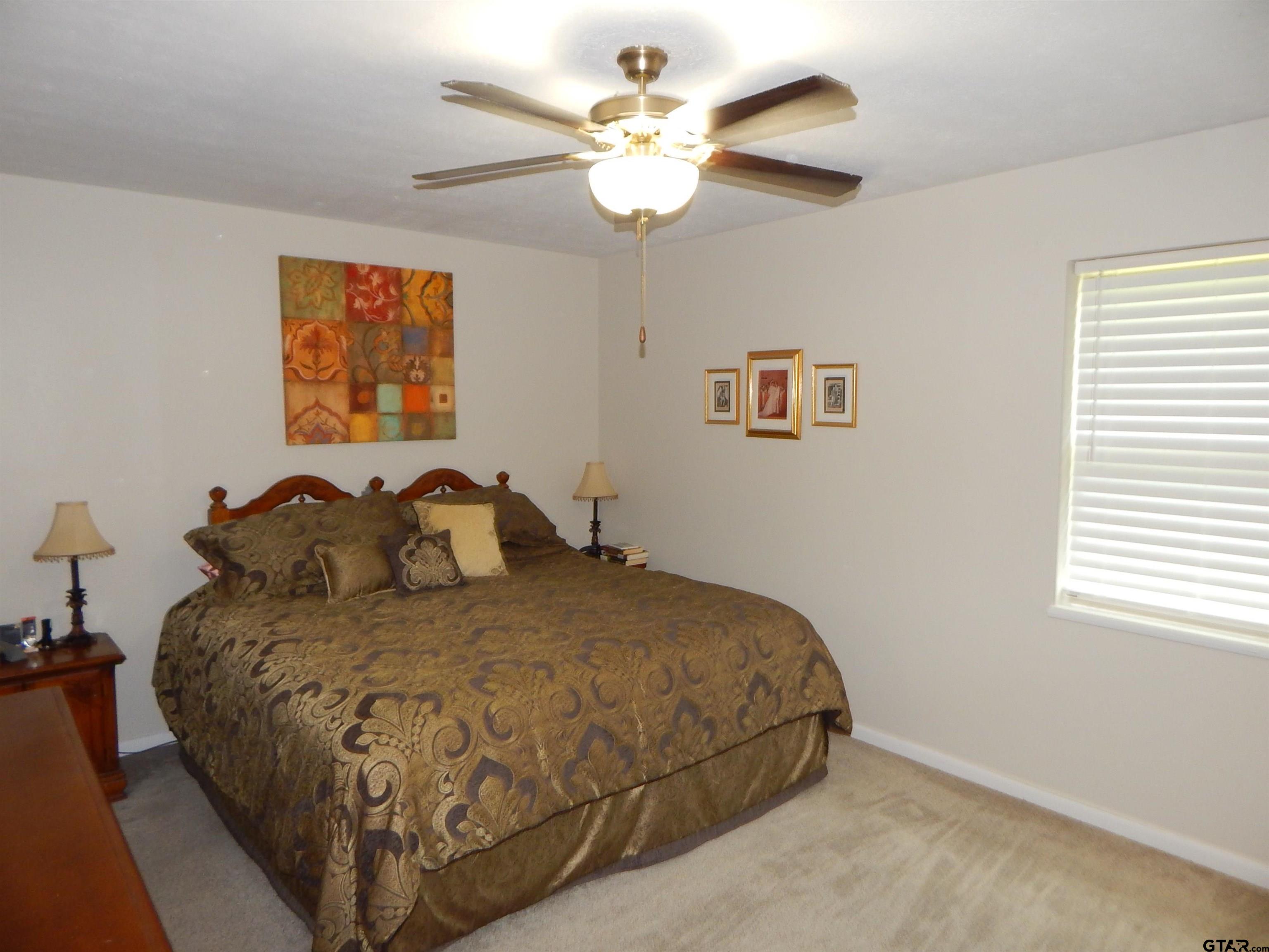 3035 Arrowwood Road Gilmer, TX 75644 - Photo 21 of 32 a bed sitting in a bedroom next to a window