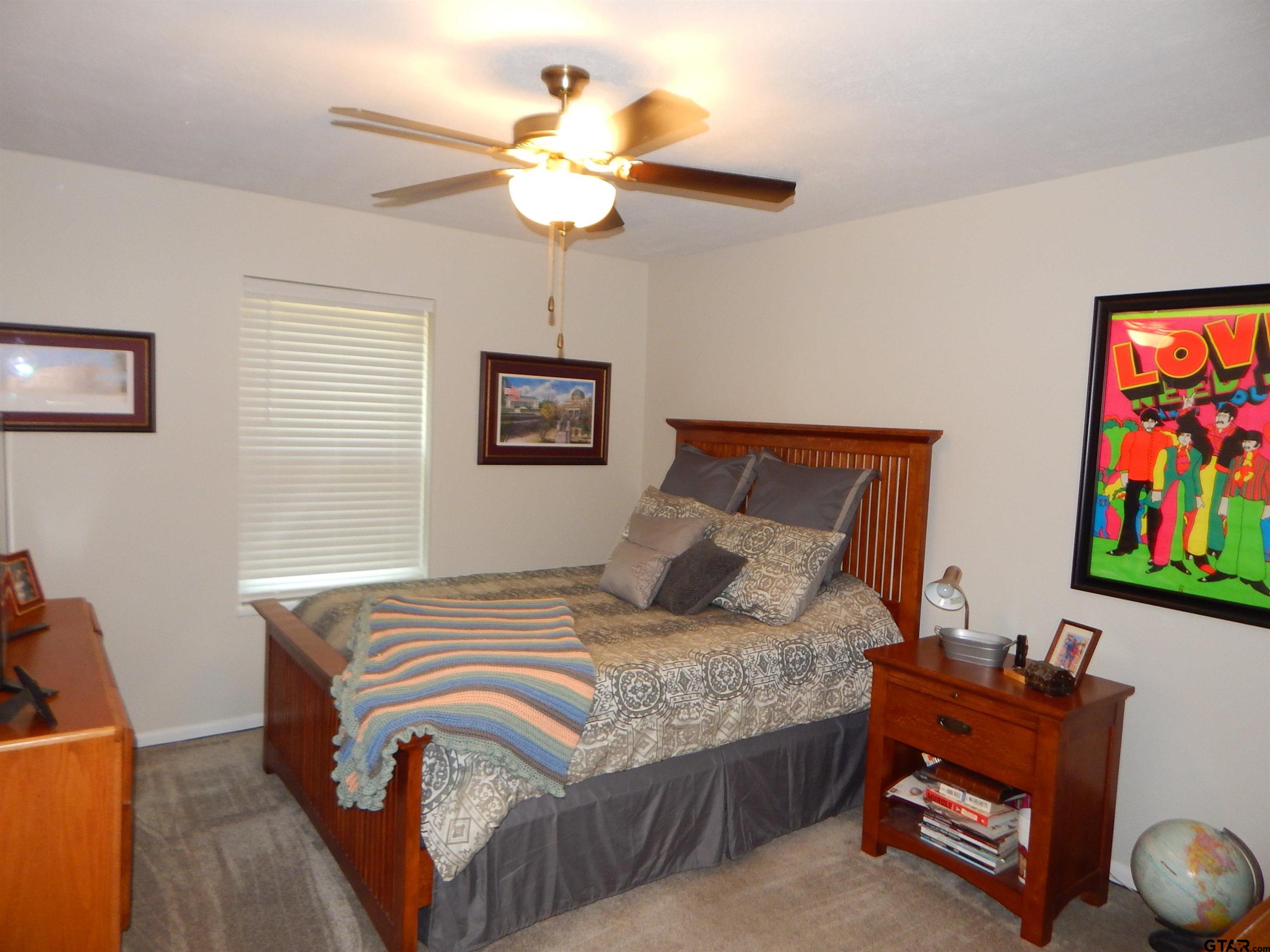 3035 Arrowwood Road Gilmer, TX 75644 - Photo 23 of 32 a bedroom with a bed and a chandelier
