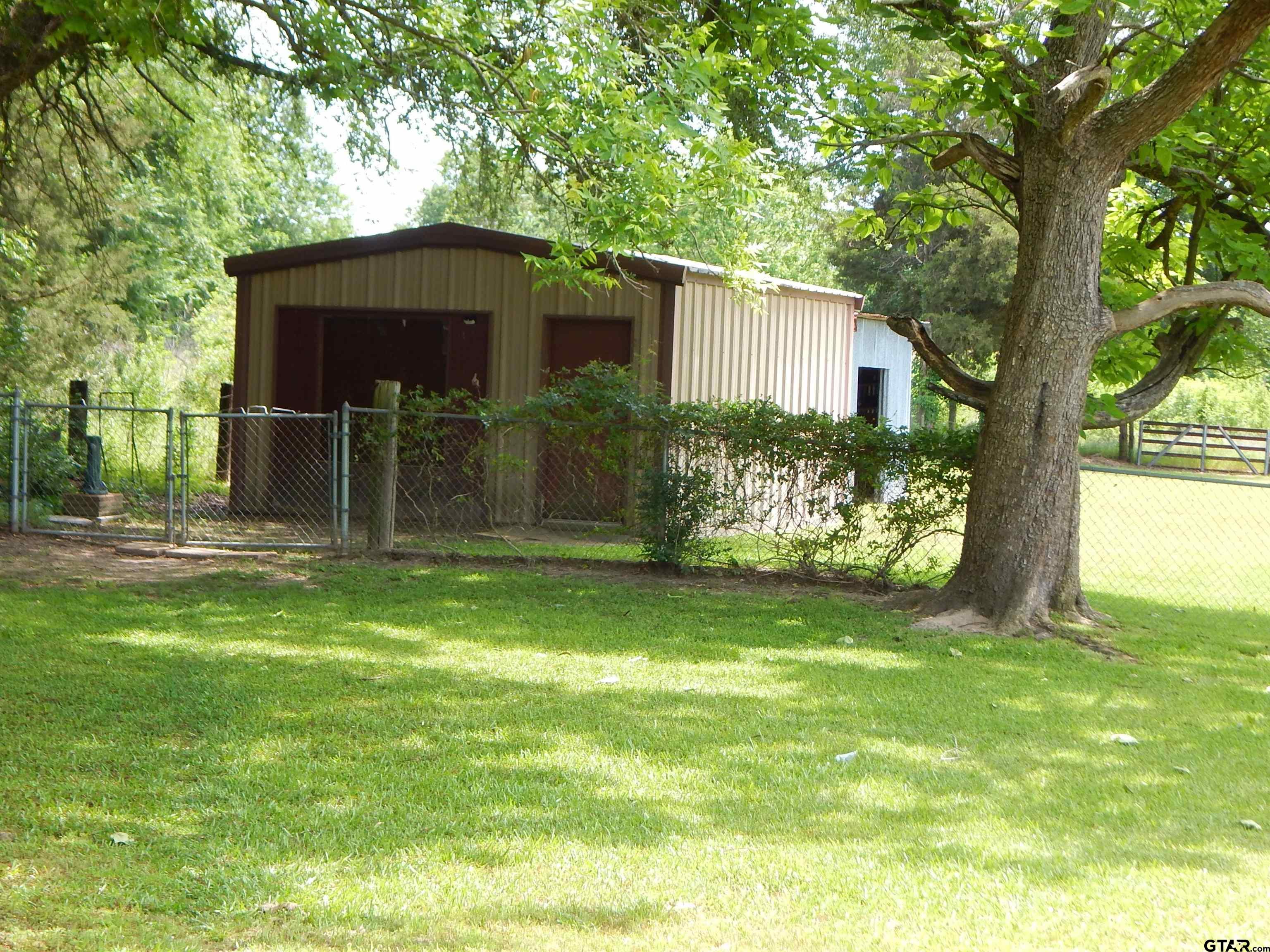 3035 Arrowwood Road Gilmer, TX 75644 - Photo 27 of 32 a backyard of a house with table and chairs