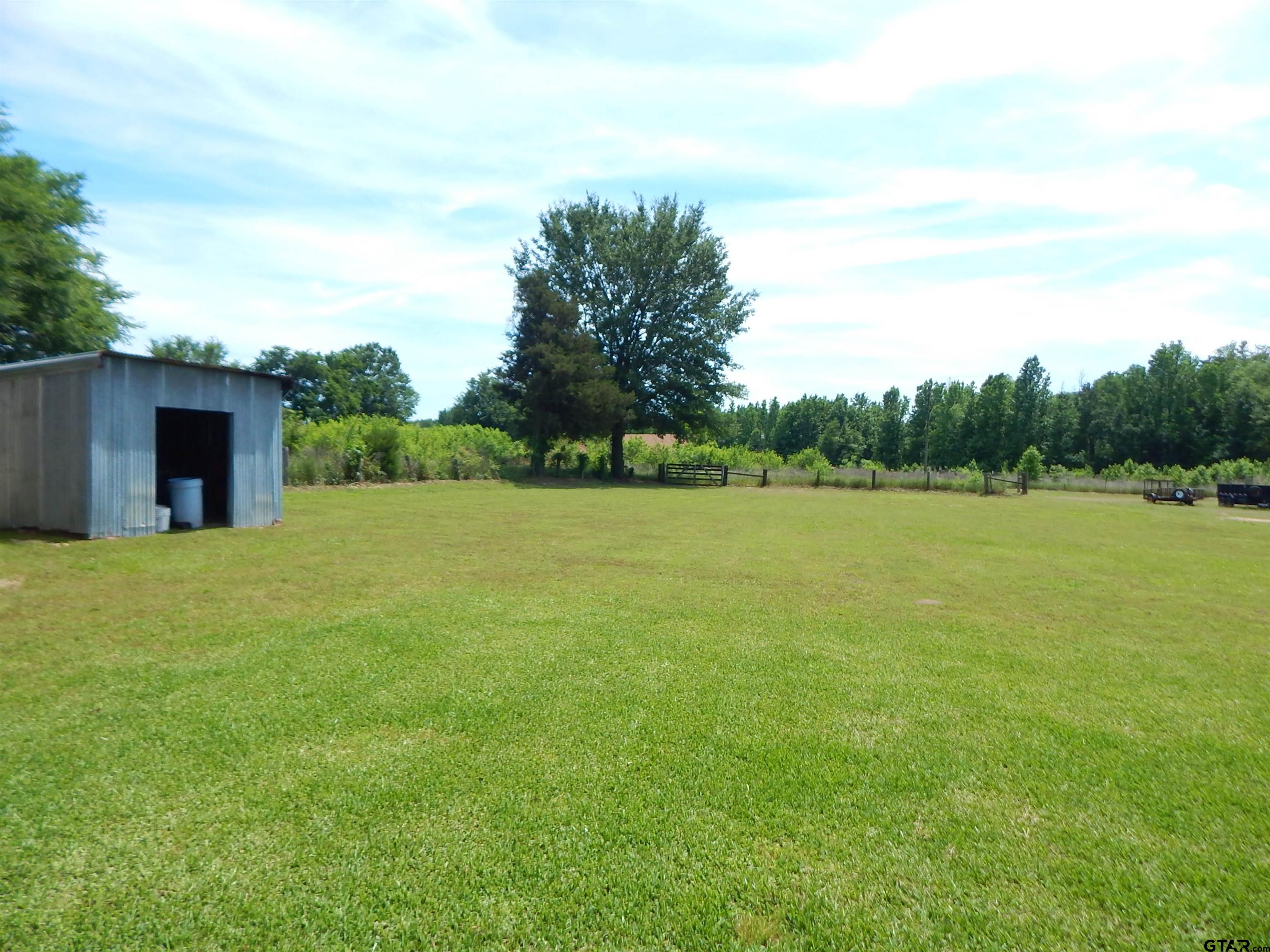 3035 Arrowwood Road Gilmer, TX 75644 - Photo 29 of 32 a backyard of a house with lots of green space and trampoline