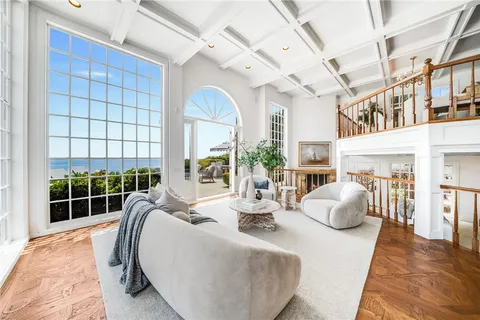 a living room with furniture a chandelier and a large window