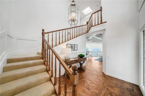 an empty room with chandelier fan and windows