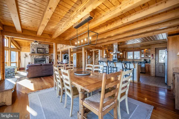 a bedroom with a bed a couch and a large window with wooden floor