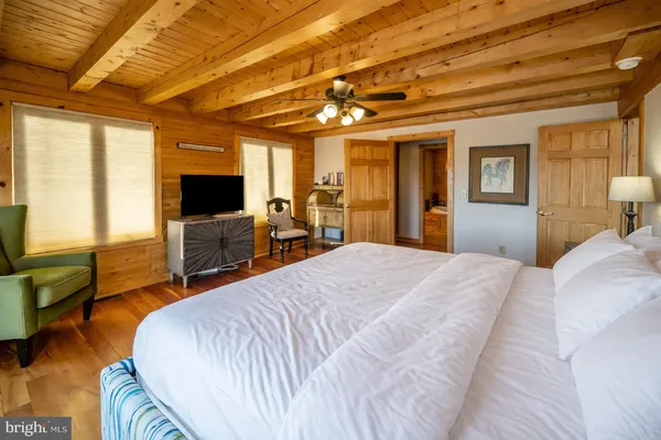 a front view of a house with a garden and lake view