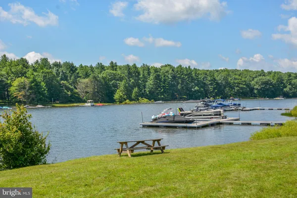 a bathroom with a granite countertop toilet a sink a mirror and a shower