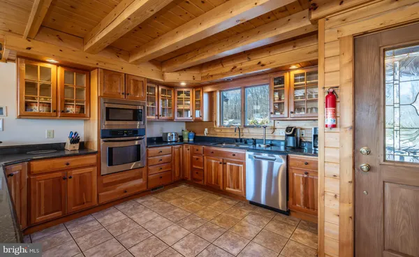 a kitchen with stainless steel appliances granite countertop a refrigerator a stove and a sink