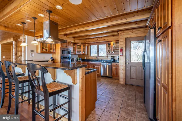 a dining room with stainless steel appliances granite countertop lots of wooden furniture