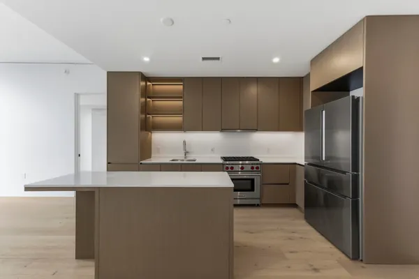 a kitchen with stainless steel appliances granite countertop a refrigerator and a stove