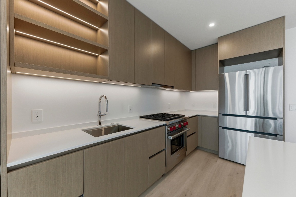 610 Davis Street, Unit 2204 Austin, TX 78701 - Photo 11 of 22 a kitchen with stainless steel appliances granite countertop a refrigerator a sink and a stove