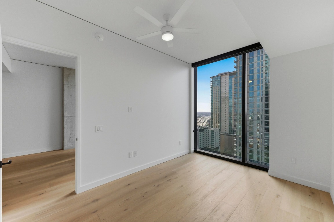 610 Davis Street, Unit 2204 Austin, TX 78701 - Photo 13 of 22 an empty room with wooden floor and windows