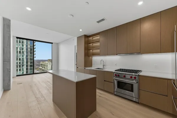 a kitchen with stainless steel appliances granite countertop a refrigerator a sink and a stove