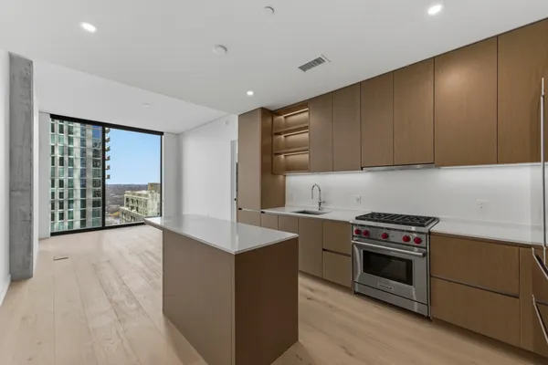 a kitchen with stainless steel appliances granite countertop a refrigerator a sink and a stove