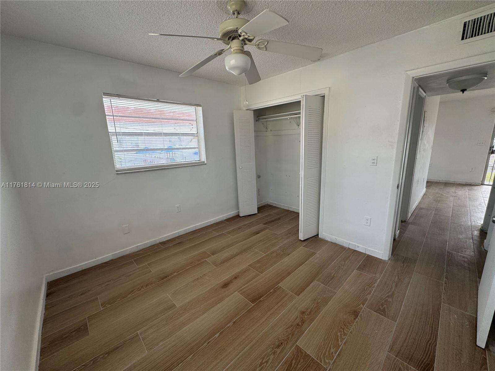 1126 Southwest 3rd Street, Unit 3 Miami, FL 33130 - Photo 8 of 9 a view of an empty room with wooden floor and a ceiling fan