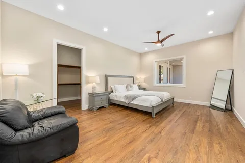 a spacious bedroom with a bed couch and a window