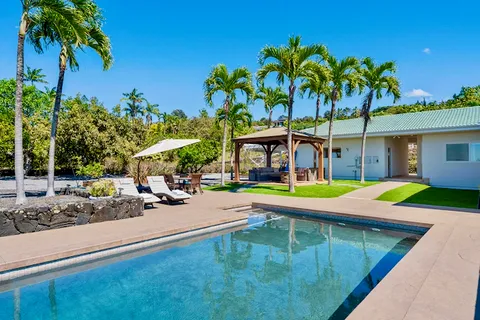 a view of a house with swimming pool and sitting area
