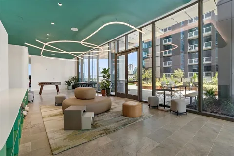 a living room with furniture and a floor to ceiling window