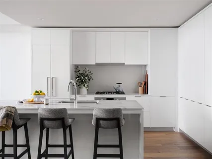 a kitchen with stainless steel appliances a white table and chairs in it
