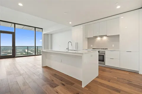 a large white kitchen with a large window