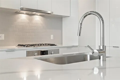 a kitchen with granite countertop a sink and wooden floor