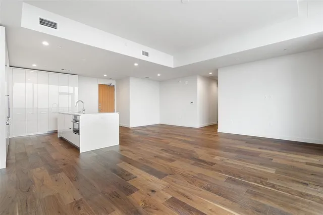 a kitchen with stainless steel appliances wooden floor and large window