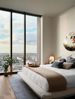 a bedroom with a bed and large windows