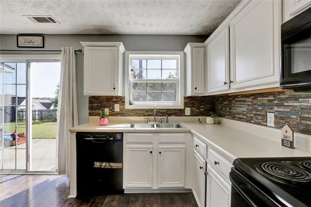 a kitchen with a sink stove top oven and cabinets