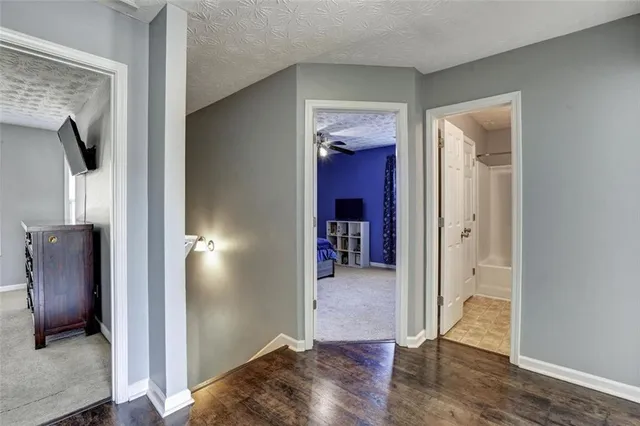 a view of a hallway with wooden floor and closet