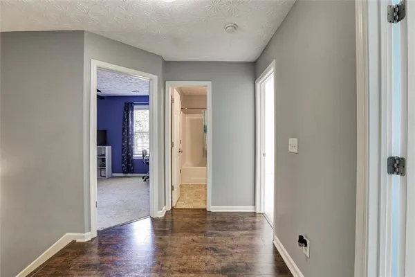 a view of a hallway with wooden floor and closet