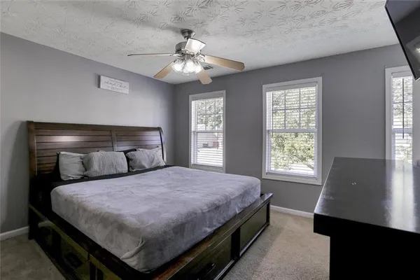 a bedroom with a large bed and a chandelier
