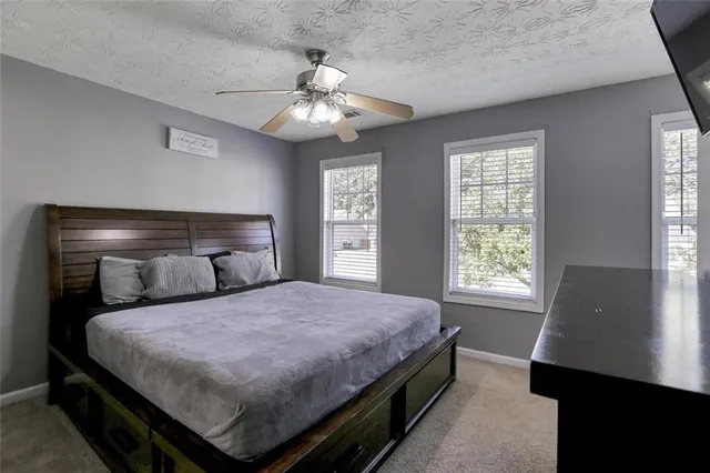 a bedroom with a large bed and a chandelier