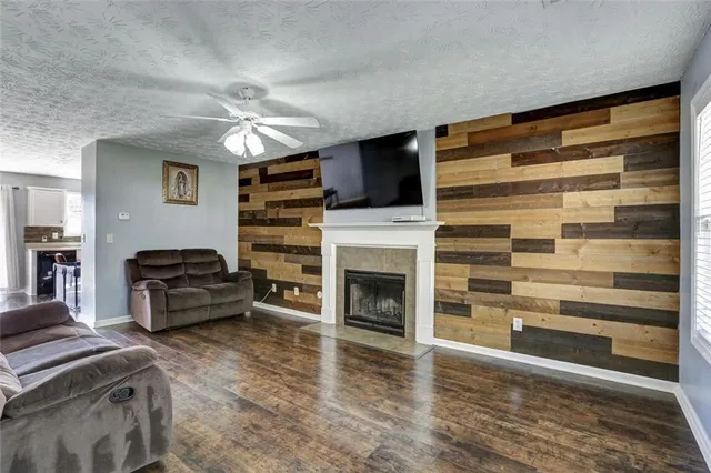 a living room with furniture a fireplace and a flat screen tv