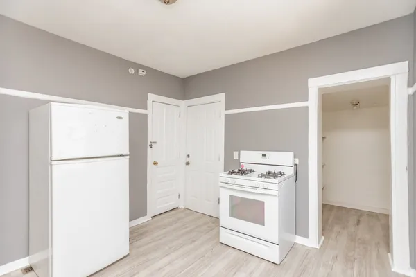 a kitchen with a stove top oven and refrigerator