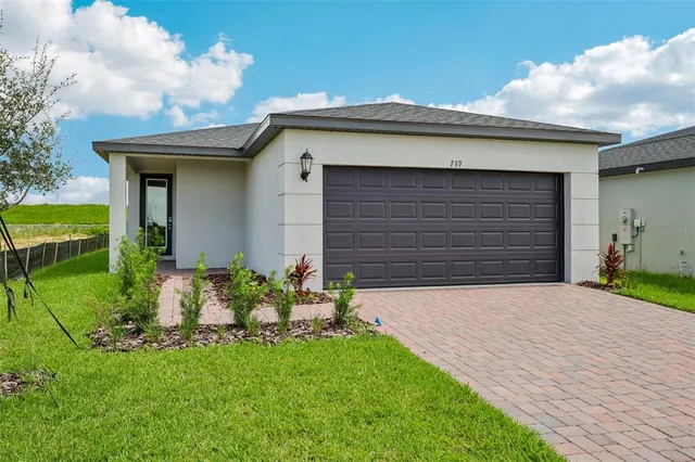 a front view of a house with a yard and garage