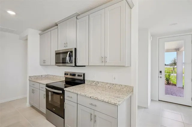 a kitchen with stainless steel appliances granite countertop white cabinets and a stove
