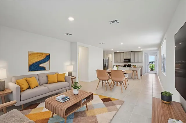 a living room with furniture kitchen view and a table