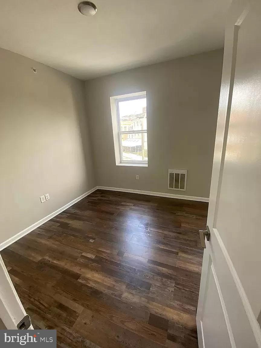 1470 North 52nd Street, Unit 2 Philadelphia, PA 19131 - Photo 2 of 8 an empty room with wooden floor and windows