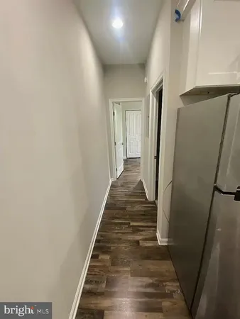 a view of a hallway with wooden floor and stairs
