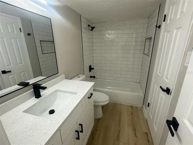 a bathroom with a sink a toilet a mirror and shower
