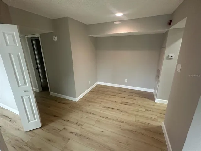 an empty room with wooden floor and a sink