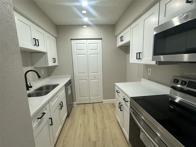 a kitchen with stainless steel appliances a sink stove and refrigerator