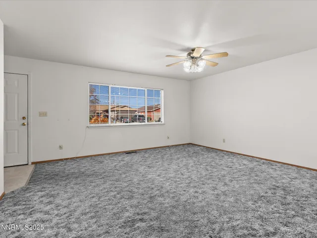 an empty room with windows and ceiling fan view