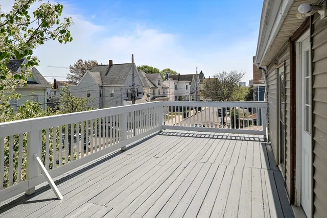 a view of a balcony with wooden floor and fence