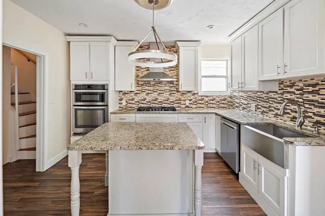 a kitchen with stainless steel appliances granite countertop a stove and a sink