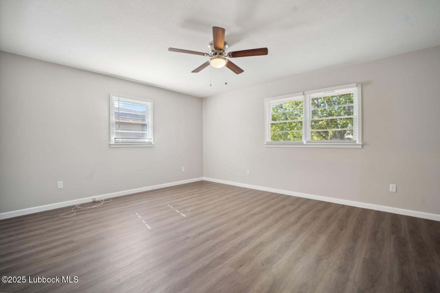 2004 45th Street Lubbock, TX 79412 - Photo 12 of 18 a view of an empty room with wooden floor and a window