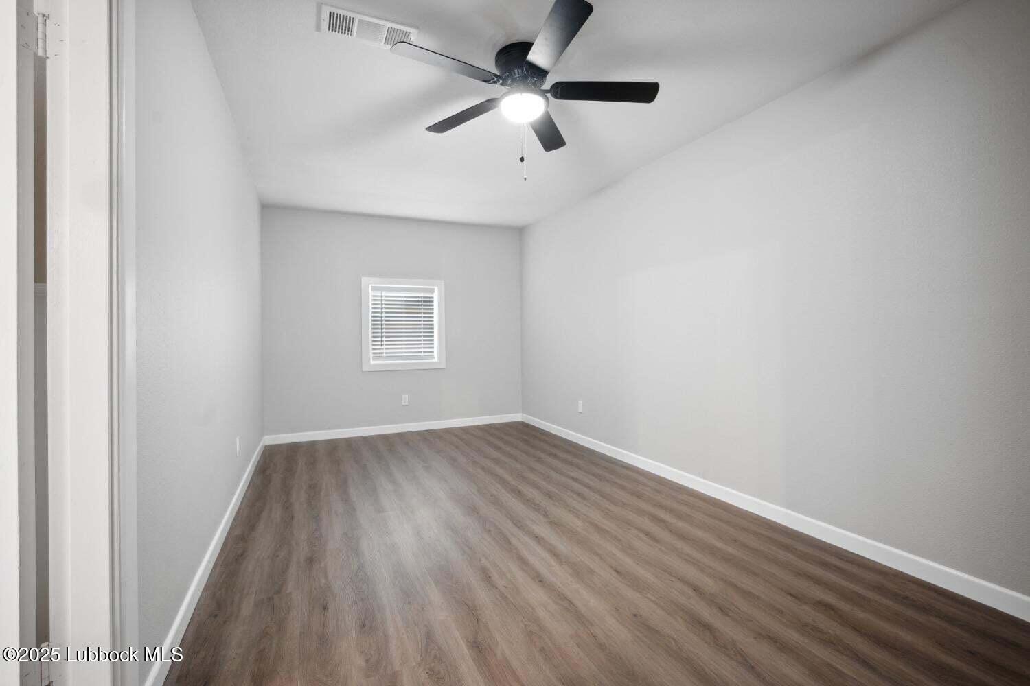 2004 45th Street Lubbock, TX 79412 - Photo 17 of 18 an empty room with a window and a ceiling fan