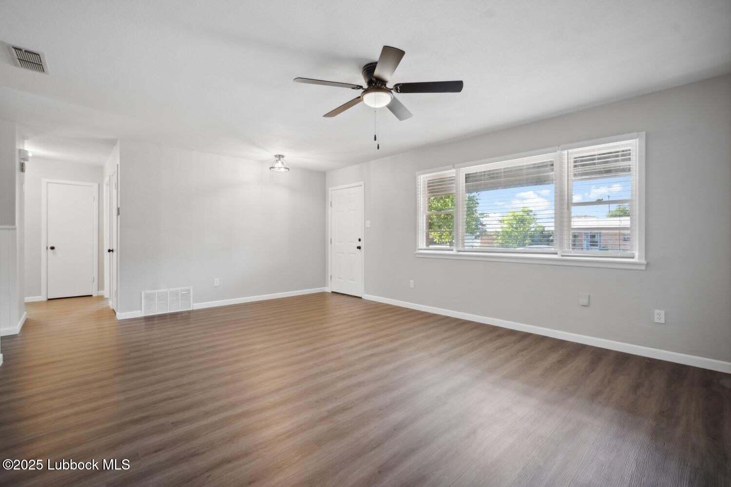 2004 45th Street Lubbock, TX 79412 - Photo 7 of 18 a view of an empty room with wooden floor and a window
