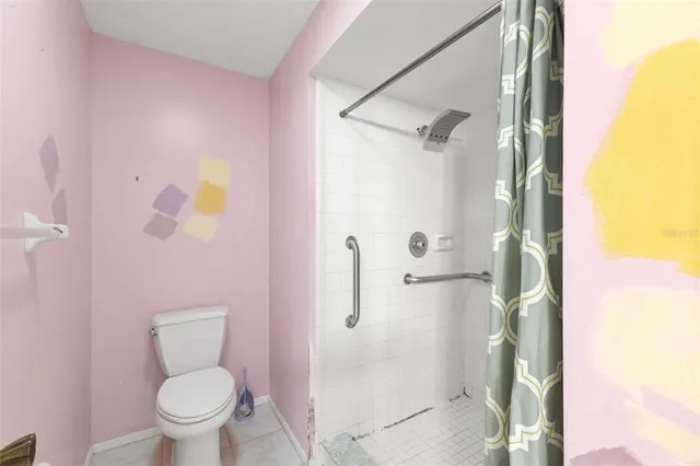 a white toilet sitting next to a shower