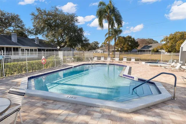 a view of a house with pool and chairs