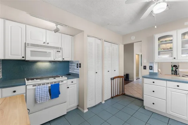 a kitchen with white cabinets and appliances